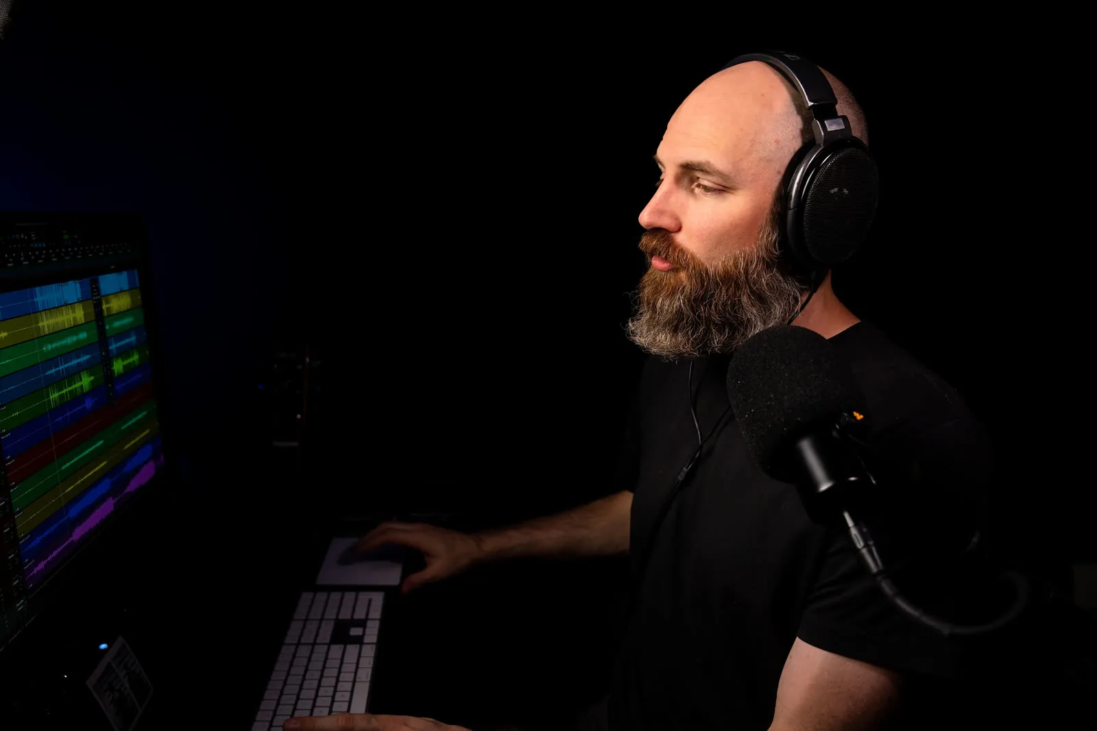 David Glenn mixing in Pro Tools, headphones on, hand on the keyboard